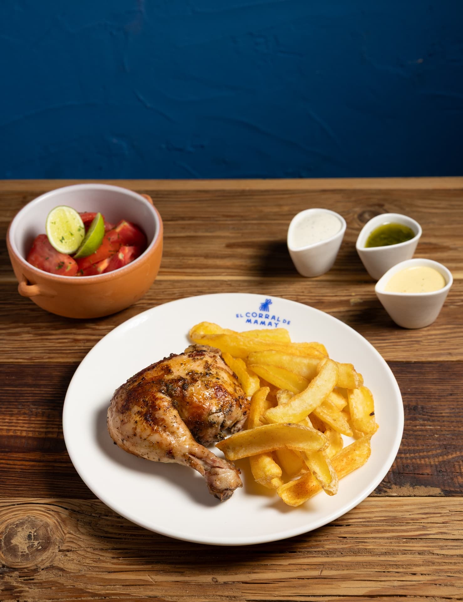 Cuarto de pollo (muslo) a la brasa, marinado con especias peruanas, acompañado de patatas, 2 salsas y ensalada a elegir (clásica o tomate) - El Corral de Mamay