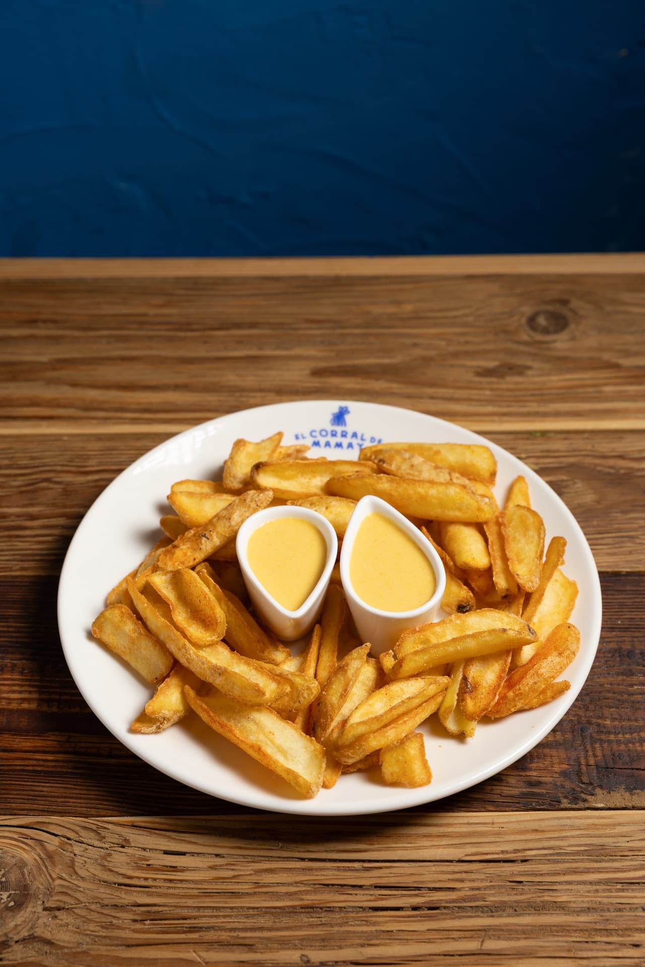 La versión peruana de un clásico: patatas crujientes abrazadas por nuestra cremosa y seductora salsa huancaína de ají amarillo y queso - El Corral de Mamay